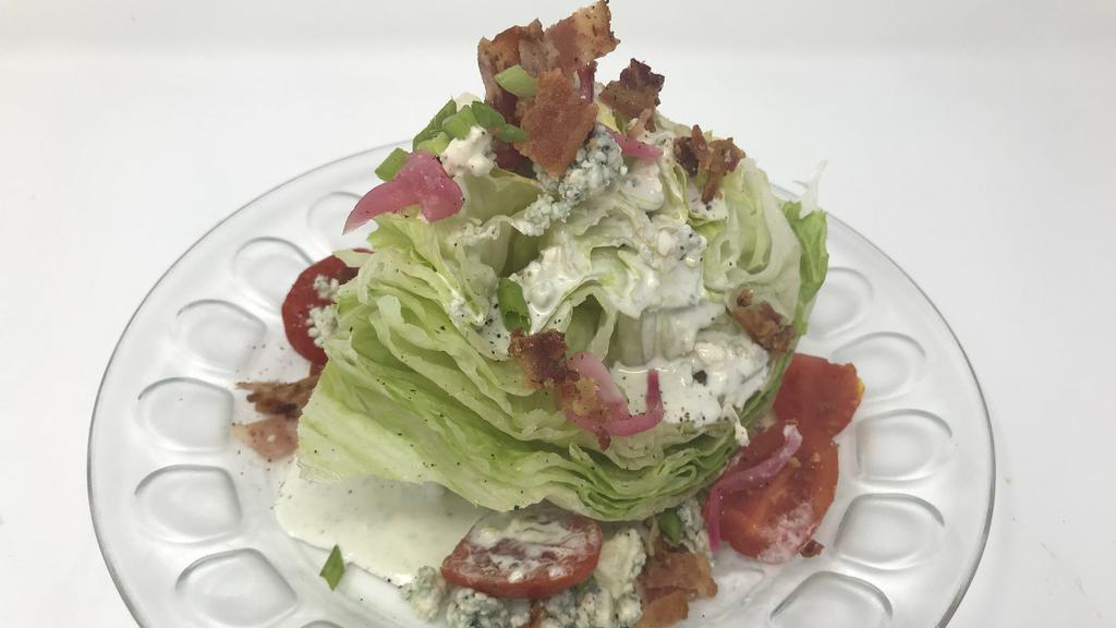 Wedge Salad · Iceberg lettuce, tomato, bacon, pickled red onion, and bleu cheese dressing.