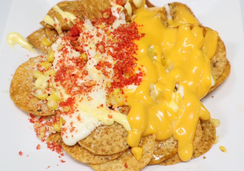 Tostielote · Tostitos topped with sweetcorn, mayonnaise, butter, nacho cheese, cotija cheese, chile powder and cheetos crumbs.
