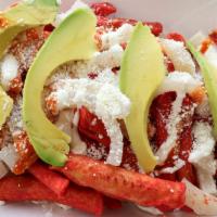 Takislokos · Takis topped with green cabbage,  pork rinds,  cheese, avocado, sour cream, and hot sauce.