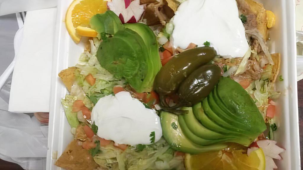 Super Nachos · El Palmar's loaded super nachos prepared with your choice of meat - topped with lettuce, tomato, cheese, beans, sour cream, and pickled jalapeños