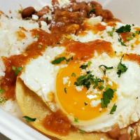 Huevos Rancheros  · 2 fried tortillas topped with 2 sunny side-up eggs with a side of rice and beans and fresh m...