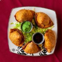Vegetable Samosas (2) · Crisp triangular patties stuffed with peas and potatoes cooked with spices and deep fried.