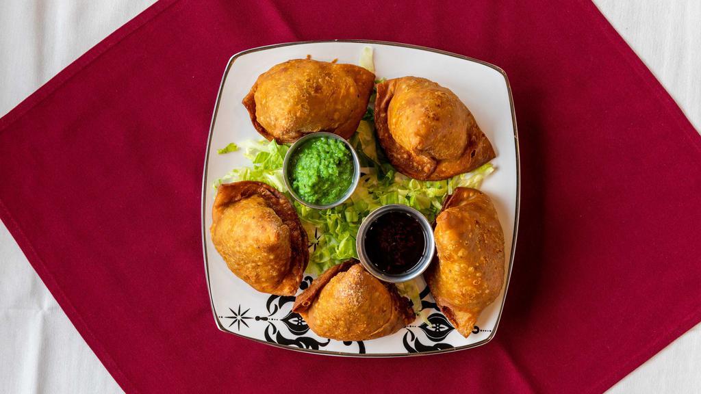 Vegetable Samosas (2) · Crisp triangular patties stuffed with peas and potatoes cooked with spices and deep fried.