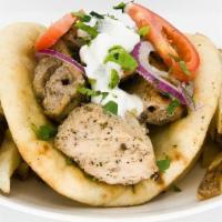 Pork Souvlaki Pita · Pieces of pork marinated in olive oil, lemon and greek spices on a pita.  Served with tzatzi...