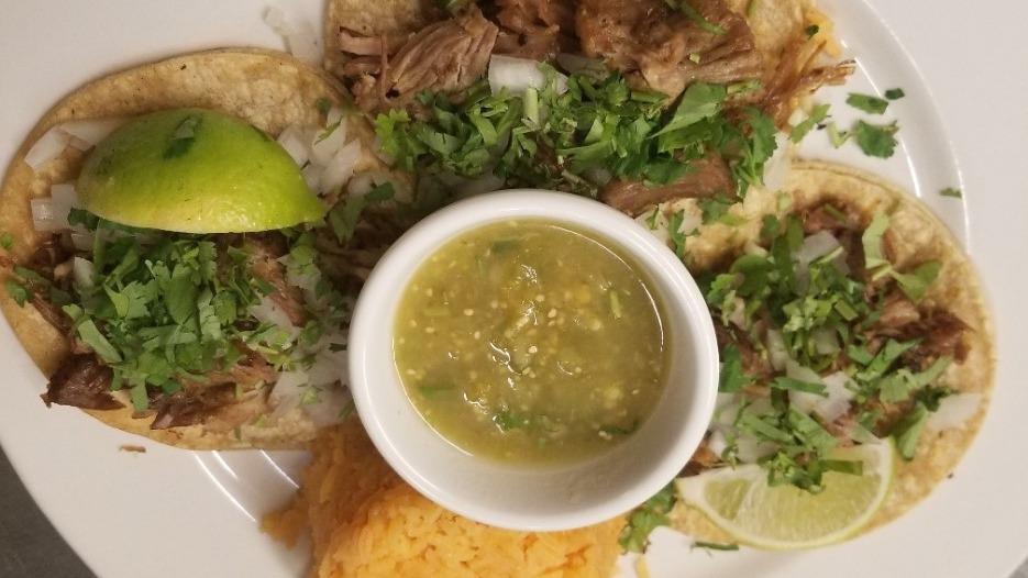 Carnitas Tacos · Three pork tacos topped with onions, cilantro, salsa verde. Served with black beans and spanish rice.