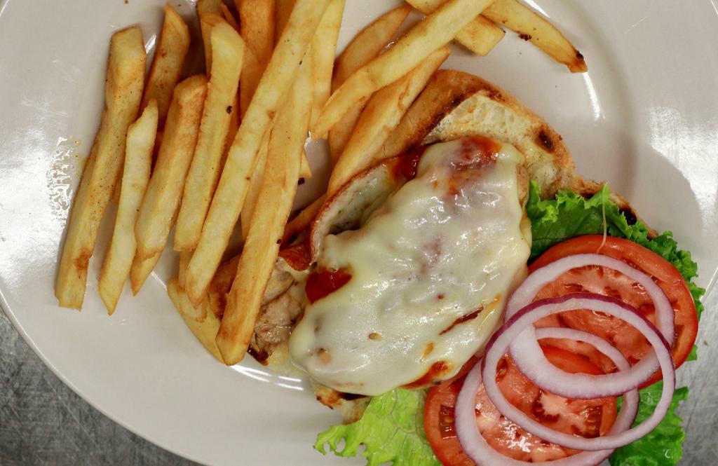 Chicken Parmesan · Chicken parmesan on a loaf of toasty garlic bread with parmesan and mozzarella cheese, lettuce, marinara sauce and french fries.