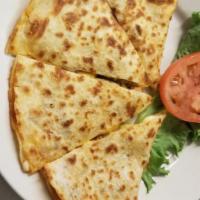 Quesadilla · Flour tortilla and melted cheese, served with sour cream and red chile sauce.