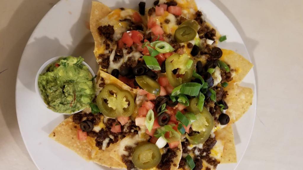 Nachos · Choice of ground beef, chicken or pork. Black beans, tomatoes, scallions, black olives and jalapenos served with guacamole.