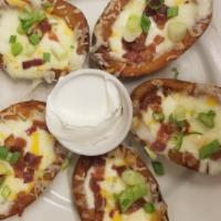 Potato Skins · Crispy potato skins filled with cheddar and monterrey jack cheese and bacon bits and scallio...