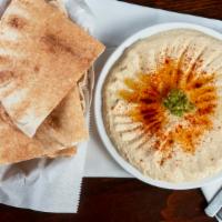 Hummus · A blend of chickpeas, tahini, garlic, lemon juice and spices. Topped with olive oil, tomatoe...