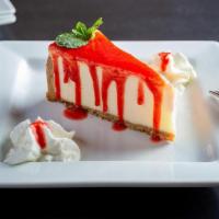 Cheesecake · Creamy cheesecake with graham cracker crust and strawberry sauce.