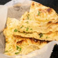 Garlic Naan · Flour-based flatbread topped with fresh garlic and cilantro.