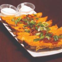 Corral Skins · Crispy potato skins smothered with Monterey jack and cheddar cheeses, bacon and green onions...