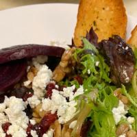 Roasted Beet Salad · Roasted beets, goat cheese, dried cranberries and walnuts tossed with spring greens and whit...
