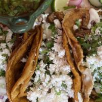 Birria Tacos · Three double corn tortilla tacos with cheese, topped with birria meat, sour cream, cilantro,...