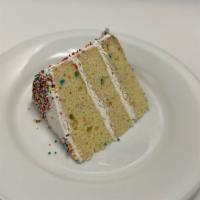 Fun Fetti Cake · A 3 layer cake slice with candy bits on the inside and sprinkles on the outside.