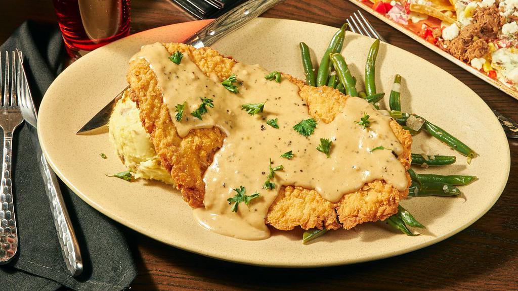 Hoosier Hot Plate · Indiana pork tenderloin, fried golden brown, topped with peppercorn gravy, served with yukon gold mashed potatoes and green beans.