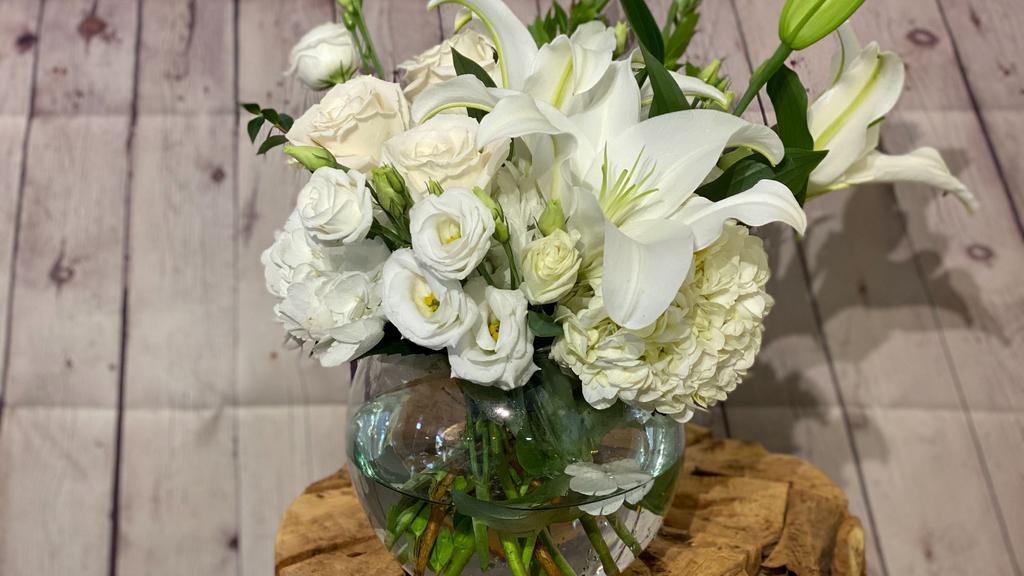 Halcyon Heart · Lilies, roses, lisianthus, and more - all shades of creamy white - are elegantly arranged in a large bubble bowl.