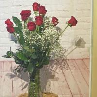A Dozen Premium Long Stem Red Rose (Vased) · 1 dozen long stem red roses with baby's breath and mixed greenery.