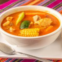 Sopa De Patas · Authentic cowheel com and vegetable soup served with rice and a slice of lime.