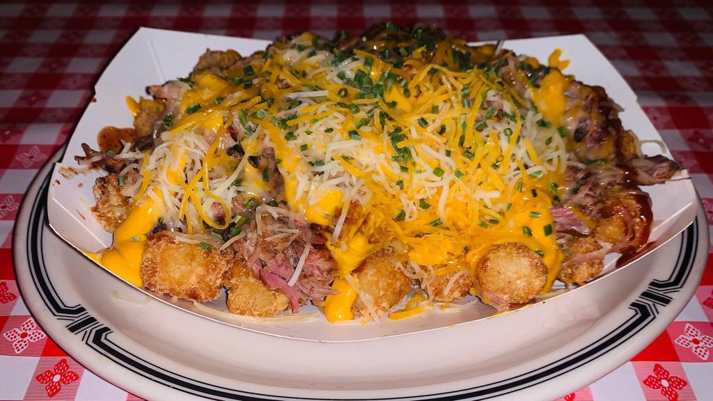 Bbq Tachos · BBQ TACHOS Perfectly fried tater tot with your choice of our signature pulled pork or chopped brisket aged cheddar cheese sauce shredded cheddar and jack cheese with chopped onions, jalapeños, sour cream, and cheese and sour cream on the side a party for One!