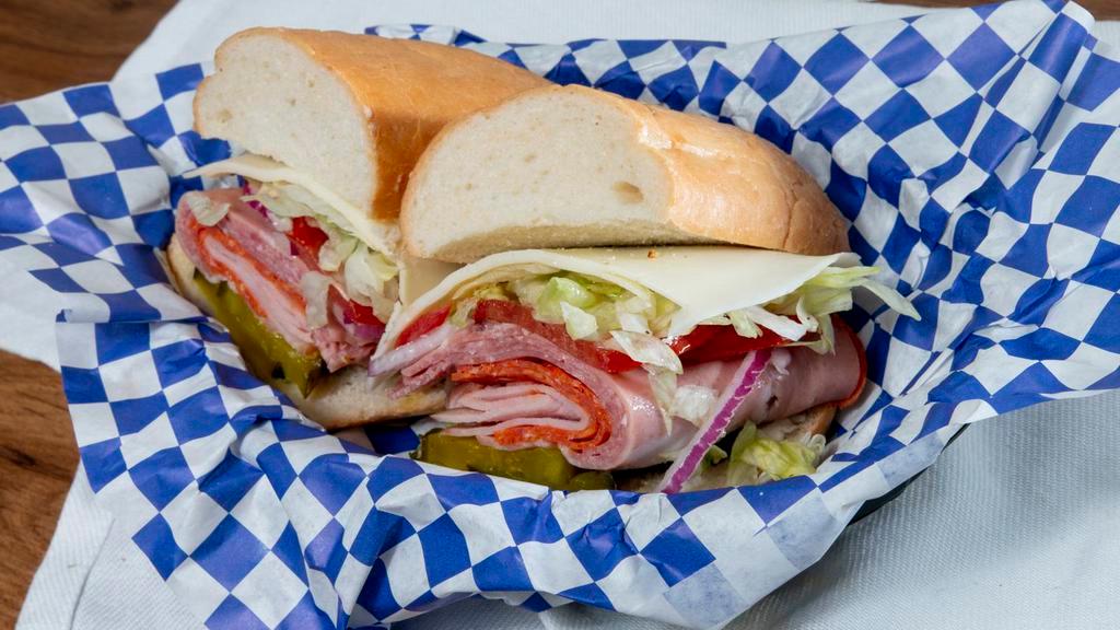Submarine Italiano · Salami, pepperoni, mortadella, ham, and provolone on an Italian roll with red onion, fresh tomatoes, sweet pickles, shredded lettuce, and herbed oil.