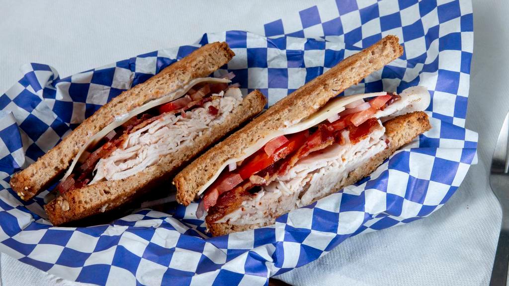 Turkey Ranch · Oven roasted turkey on toasted whole grain bread with ranch dressing, applewood smoked bacon, Swiss cheese, fresh tomatoes and red onion.