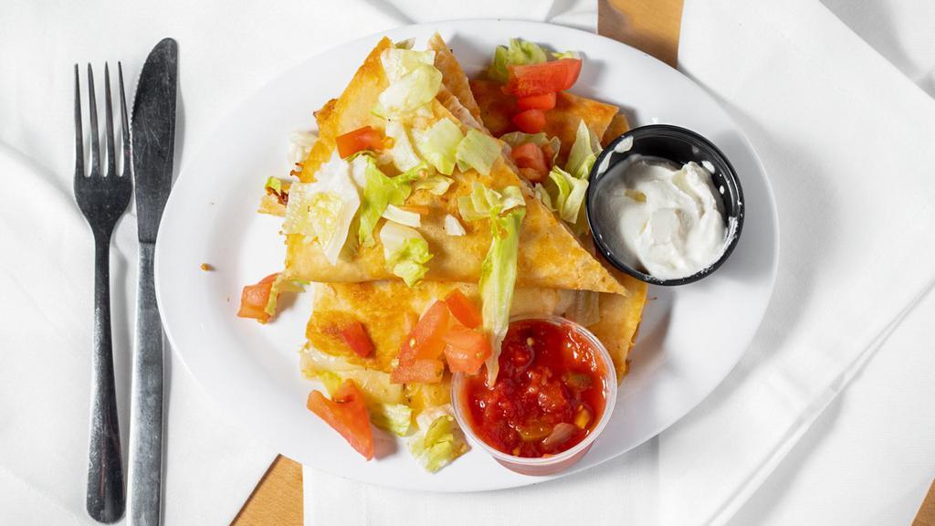 Chicken Quesadilla · Grilled flour tortilla filled with blended cheeses and juicy grilled chicken. Served with lettuce, tomato, sour cream and salsa on the side.