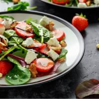 Strawberry Feta Salad · Organic mixed greens tossed with strawberries, grapes, pecan, raisins, feta cheese and balsa...