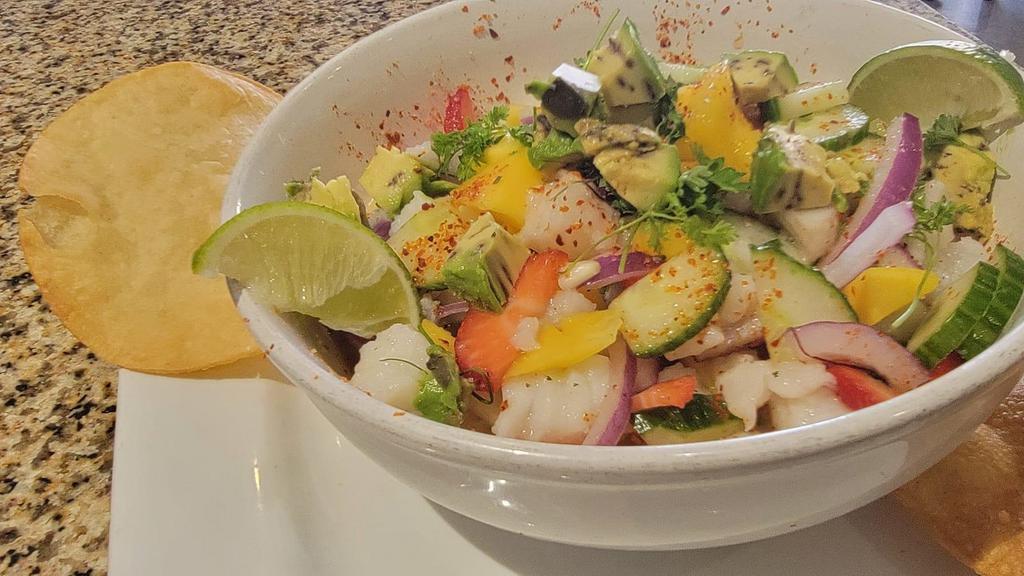 Mango Fish Ceviche · Cod pieces cooked in lime juice, spices, red onions, cucumber, mango and strawberries, served with tostadas