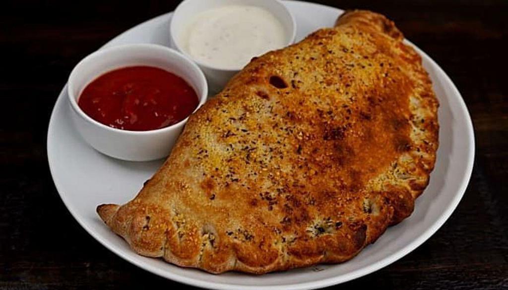 The Meats Calzone · Our house tomato sauce, house cheese blend, mild sausage, pepperoni, bacon and Italian beef.