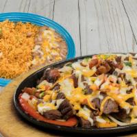 Parrillada · Chicken, beef or shrimp with bacon, onions, bell peppers and melted cheese on top. Served wi...