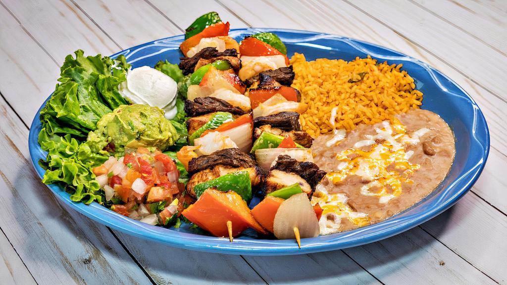 Brochetas · Two brochetas filled with steak, chicken, shrimp, bell pepper and onions. Served with guacamole, sour cream, pico de gallo and two sides.