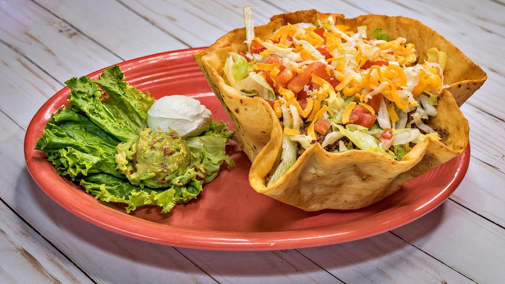 Taco Salad · Filled with chicken or beef, beans, lettuce, tomatoes and cheese, served with guacamole and sour cream. Made with fajita meat for an additional charge.