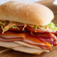 Nashotah Sunset Sandwich · Red pepper pesto spread on a toasted ciabatta with our rotisserie turkey, ham, bacon, chedda...