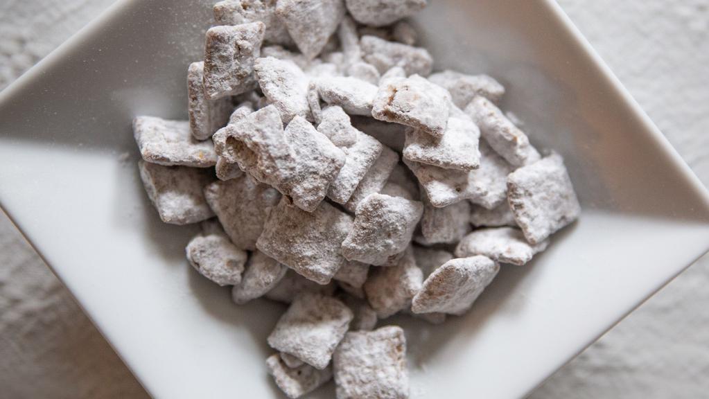 Puppy Chow · Creamy peanut butter and chocolate coated cereal covered in powdered sugar.