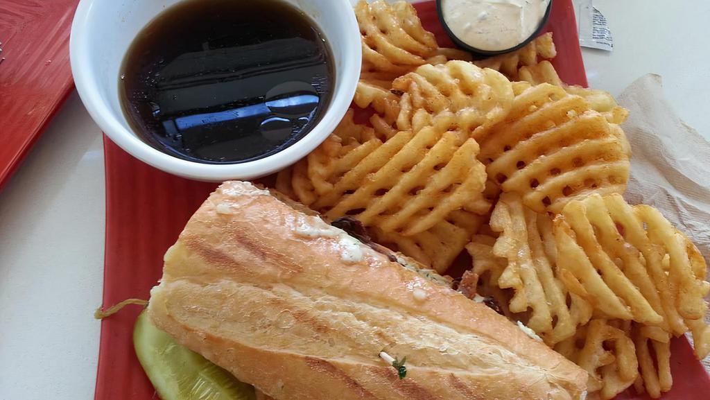 French Dip · Thinly sliced prime rib with a garlic herb spread and onion straws served with a side of au jus.