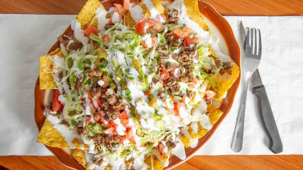 Nachos Supreme · Nacho supreme includes lettuce, tomato. Melted Mexican cheese, beans, guacamole,​ sour cream and your choice of meat