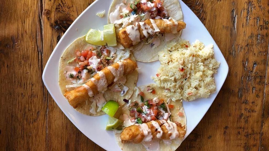 Fish Tacos · Three corn tortillas filled with Asian slaw and beer battered fish then topped with pico de gallo and chipotle ranch. Served with lemon butter rice.