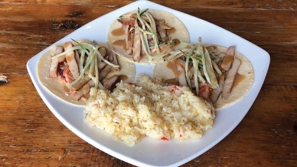 Bulgogi Tacos · Three corn tortillas filled with a kimchi-style slaw, marinated pork, cucumber sunomono and a sweet soy aioli. Served with lemon butter rice.
