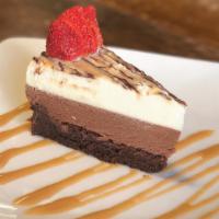 Triple Chocolate Mousse Cake · Light and airy layers of white and milk chocolate mousse atop a flourless chocolate cake fin...