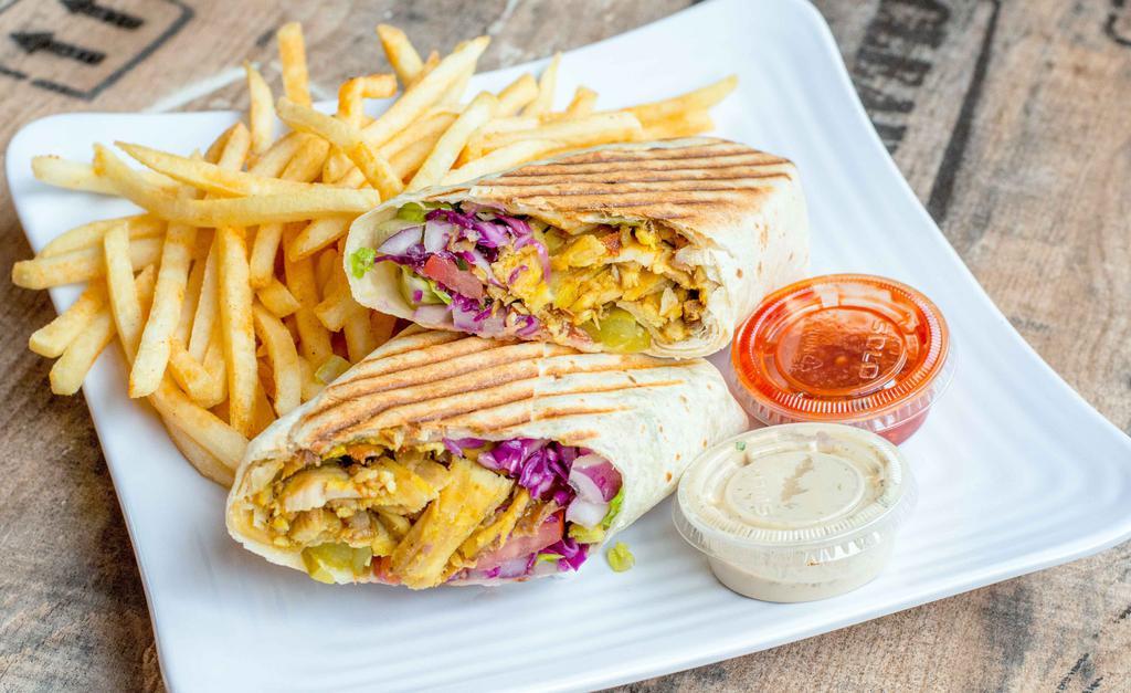 Chicken Shawarma Wrap · Marinated chicken cooked to perfection served with romaine lettuce, onions, tomato, tahini sauce, cucumber and pickles.