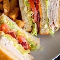 Turkey Club · Slow-roasted turkey breast, hickory-smoked bacon, American and Swiss cheeses on grilled sour...