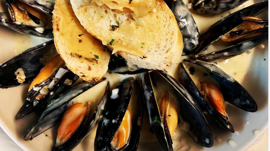 Mussels Marinieres · Tossed with fresh herbs, shallots and white wine cream sauce served with garlic bread.