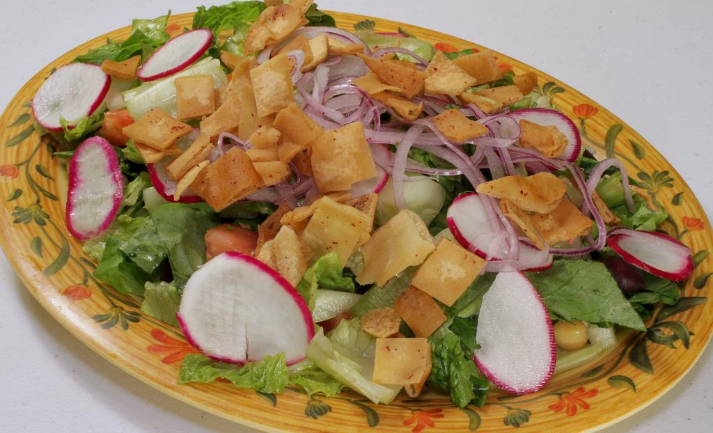 Fattoush Salad · Chopped Romaine lettuce, tomato, onion, cucumber, parsley, radishes and sumac topped with olive oil  house dressing and toasted pita chips.