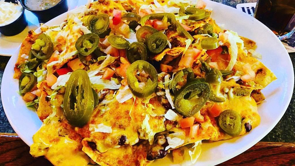 Muy Grande Nachos · Homemade crispy tortilla chips topped with refried beans, cheese, lettuce, tomato, Jalapeños, and sour cream.