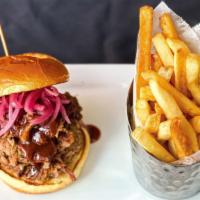 Texas-Style Chopped Beef Brisket Sandwich · Each brioche bun sandwich is stacked with a heaping pile of tender, chopped brisket, pickled...