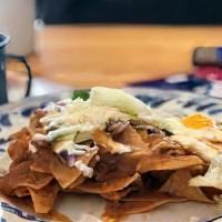 Chilaquiles · Pieces of golden tortilla with red or green sauce, eggs, cheese and onion. Served with rice ...