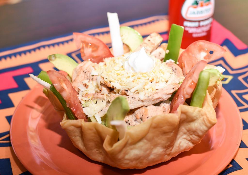 Grilled Chicken Taco Salad · Crisp flour shell filled with refried beans, lettuce, grilled chicken. Topped with shredded cheese, chopped tomato, green pepper, green onion, avocado, green olives, and sour cream.