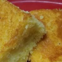 Corn Bread · Two pieces of fresh baked cornbread. Our  secret recipe. Just like everything else here, smo...